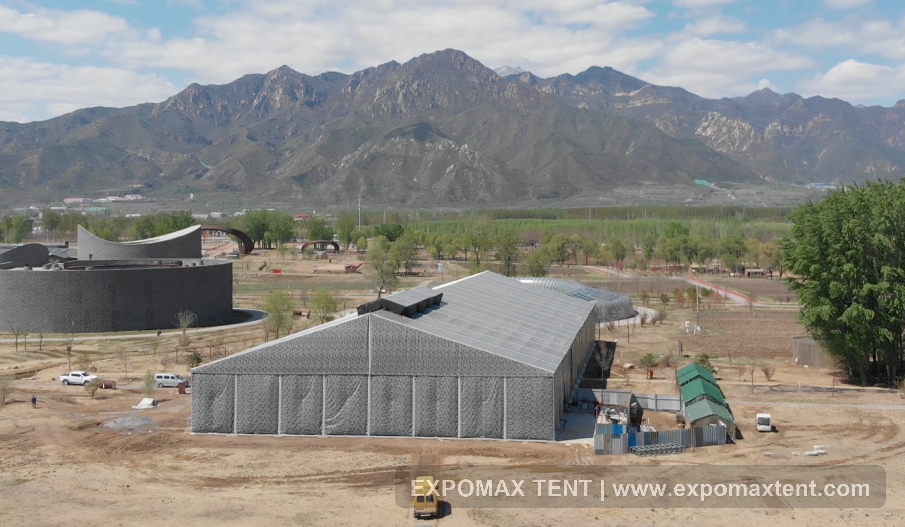 Large scenic event venue tent with mountain background