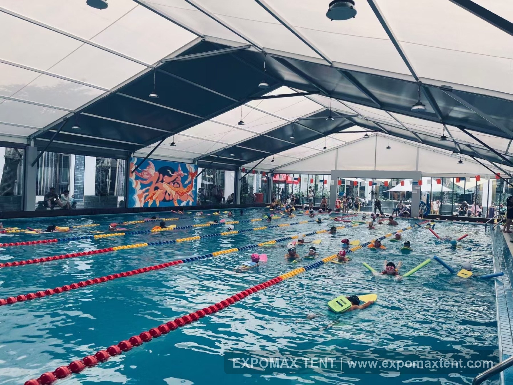 Swimming pool covered by a tent structure